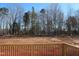 Wooded backyard view from the deck features bare trees and freshly cleared ground, ready for landscaping at 1403 Reading Ct # 75 Kl, Burlington, NC 27217