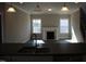 Open-concept living room with fireplace is viewed from the kitchen featuring dark hardwood floors and neutral walls at 1403 Reading Ct # 75 Kl, Burlington, NC 27217