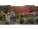 Aerial view featuring well-maintained homes with solar panels near a serene pond surrounded by lush trees at 144 Elk Stone Trl, Garner, NC 27529
