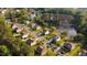 Aerial view of neighborhood homes nestled along a tranquil lake with mature trees and lush landscaping at 144 Elk Stone Trl, Garner, NC 27529