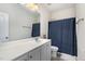 Bathroom with blue shower curtain, vanity with modern faucet and neutral tones at 144 Elk Stone Trl, Garner, NC 27529