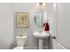 Half bathroom with pedestal sink, oval mirror, and framed wall art above the toilet at 144 Elk Stone Trl, Garner, NC 27529