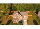 Charming two-story brick home boasts solar panels, manicured lawn, and surrounded by lush greenery at 144 Elk Stone Trl, Garner, NC 27529