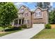 Two-story brick home boasts an attached two-car garage, well-manicured lawn, and covered front porch at 144 Elk Stone Trl, Garner, NC 27529