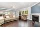 Cozy living room with hardwood floors, a fireplace, and large windows that flood the space with natural light at 144 Elk Stone Trl, Garner, NC 27529