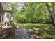 Lush backyard featuring a stone pathway, mature trees, and well-maintained landscaping at 1506 Ephesus Church Rd, Chapel Hill, NC 27517