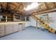 Spacious basement featuring storage cabinets, exposed ceiling structure, and wooden stairs at 1506 Ephesus Church Rd, Chapel Hill, NC 27517