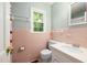 Bathroom with pink tile, a white sink and toilet, plus a window for natural light at 1506 Ephesus Church Rd, Chapel Hill, NC 27517