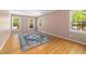 Sunny bedroom with hardwood floors, three windows, and a stylish area rug at 1506 Ephesus Church Rd, Chapel Hill, NC 27517