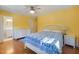 Bright bedroom featuring hardwood floors, a ceiling fan, and a white dresser with a blue patterned bedspread at 1506 Ephesus Church Rd, Chapel Hill, NC 27517