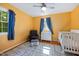 This bedroom has hardwood floors, a ceiling fan and a blue chair, as well as natural light from the window at 1506 Ephesus Church Rd, Chapel Hill, NC 27517
