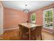 Cozy dining room with hardwood floors, a chandelier, and natural light from two windows at 1506 Ephesus Church Rd, Chapel Hill, NC 27517