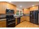 Modern kitchen featuring stainless steel appliances, granite countertops, and wooden cabinets at 1506 Ephesus Church Rd, Chapel Hill, NC 27517