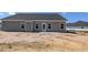 A view of the rear of the house, showing the back porch and the yard ready for landscaping at 1590 Pecan Drive # 45, Nashville, NC 27856