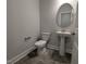 Powder room featuring a pedestal sink, oval mirror, white toilet, neutral walls and gray tile flooring at 1590 Pecan Drive # 45, Nashville, NC 27856