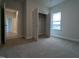 A bright bedroom with neutral walls and carpet, closet, and a large window at 1590 Pecan Drive # 45, Nashville, NC 27856