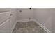 Laundry room with gray tile floors, white walls, utility hookups and a door for easy access at 1590 Pecan Drive # 45, Nashville, NC 27856