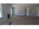 Bright living room with a stone fireplace, large windows, and doorway to another room at 1590 Pecan Drive # 45, Nashville, NC 27856
