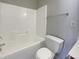 Well-lit bathroom with a shower-tub combo, toilet, towel rack, and electrical outlet at 1610 Oxleymare Dr, Raleigh, NC 27610