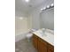 Bathroom featuring vanity with storage, tub-shower combo, and neutral tile flooring at 1610 Oxleymare Dr, Raleigh, NC 27610