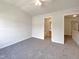 Bright bedroom with plush carpet and a ceiling fan, plus an ensuite bathroom and access to the upper level at 1610 Oxleymare Dr, Raleigh, NC 27610