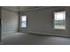 A bedroom with two windows, gray walls, white trim, and carpet at 1635 Pecan Drive # 26, Nashville, NC 27856