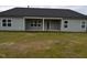 Exterior of the home featuring a back patio, gray siding, windows, and a spacious yard at 1640 Pecan Drive # 44, Nashville, NC 27856