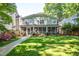 Expansive backyard featuring a screened porch, lush lawn, and meticulously landscaped flower beds at 1714 Carson St, Raleigh, NC 27608