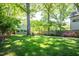 Lush backyard with a mature tree shading the grass, flowers, and an outbuilding, providing a serene environment at 1714 Carson St, Raleigh, NC 27608