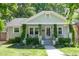 Charming home featuring a landscaped front yard, covered porch with swing, and traditional architectural details at 1714 Carson St, Raleigh, NC 27608