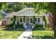 Charming home featuring a landscaped front yard, covered porch with swing, and traditional architectural details at 1714 Carson St, Raleigh, NC 27608