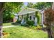 Quaint home featuring a landscaped front yard, covered porch, brick chimney, and traditional architectural details at 1714 Carson St, Raleigh, NC 27608