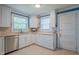 Bright kitchen with stainless steel dishwasher, tile countertops and white cabinets at 1714 Carson St, Raleigh, NC 27608