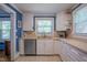 Bright kitchen with stainless steel dishwasher, tile countertops and white cabinets at 1714 Carson St, Raleigh, NC 27608