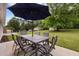 Outdoor patio space with table, chairs, and large tree offering shade in backyard at 1734 Stage Rd, Durham, NC 27703