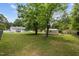 Wide backyard showcasing a storage shed, home exterior, patio area, and mature trees at 1734 Stage Rd, Durham, NC 27703