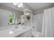 Bright bathroom featuring a modern vanity, toilet, and shower-tub combo with white tiles at 1734 Stage Rd, Durham, NC 27703
