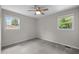 Cozy bedroom with a ceiling fan, plush carpeting, and two windows that offer a view of the neighborhood at 1734 Stage Rd, Durham, NC 27703