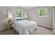 Bright bedroom with a comfortable bed, neutral color scheme, and two windows offering natural light and garden views at 1734 Stage Rd, Durham, NC 27703