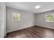 Bedroom featuring wood-look floors, white trim, and a window showcasing exterior view at 1734 Stage Rd, Durham, NC 27703