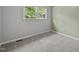 Comfortable bedroom with neutral paint, carpet flooring, and a window overlooking the outdoors at 1734 Stage Rd, Durham, NC 27703
