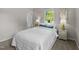 Comfortable bedroom featuring a well-dressed bed, neutral decor, and two windows providing natural light at 1734 Stage Rd, Durham, NC 27703