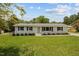 Charming single-story home with crisp white painted brick, manicured lawn, and contrasting black shutters and light-green door at 1734 Stage Rd, Durham, NC 27703