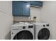 Well-equipped laundry room with blue cabinets, washer, dryer, and storage at 1734 Stage Rd, Durham, NC 27703