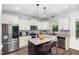 Stylish kitchen featuring white cabinets, granite countertops, stainless appliances, and an island with seating at 180 Long Grass Dr, Smithfield, NC 27577
