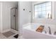 Relaxing bathroom showcasing a soaking tub, a separate shower, and a large window at 180 Long Grass Dr, Smithfield, NC 27577