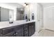 Bathroom featuring a dual-sink vanity with dark cabinets, modern lighting, and tile floors at 180 Long Grass Dr, Smithfield, NC 27577