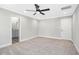 Neutral bedroom features carpet flooring, ceiling fan, and doorway to ensuite bathroom with vanity at 185 Millwood Dr, Clayton, NC 27527