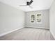 Well-lit bedroom featuring neutral paint, carpet, a ceiling fan, and windows with a view at 185 Millwood Dr, Clayton, NC 27527