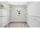 Carpeted walk-in closet featuring a window for natural light and wire shelving at 185 Millwood Dr, Clayton, NC 27527